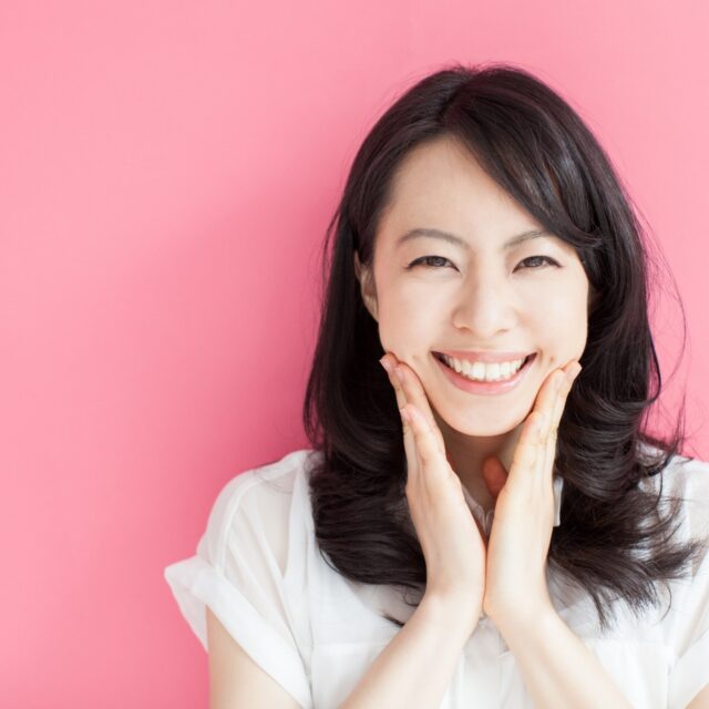 happy young woman against pink background